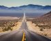 Classic panorama view of an endless straight road running through the barren scenery of the American Southwest with extreme heat haze on a beautiful hot sunny day with blue sky in summer